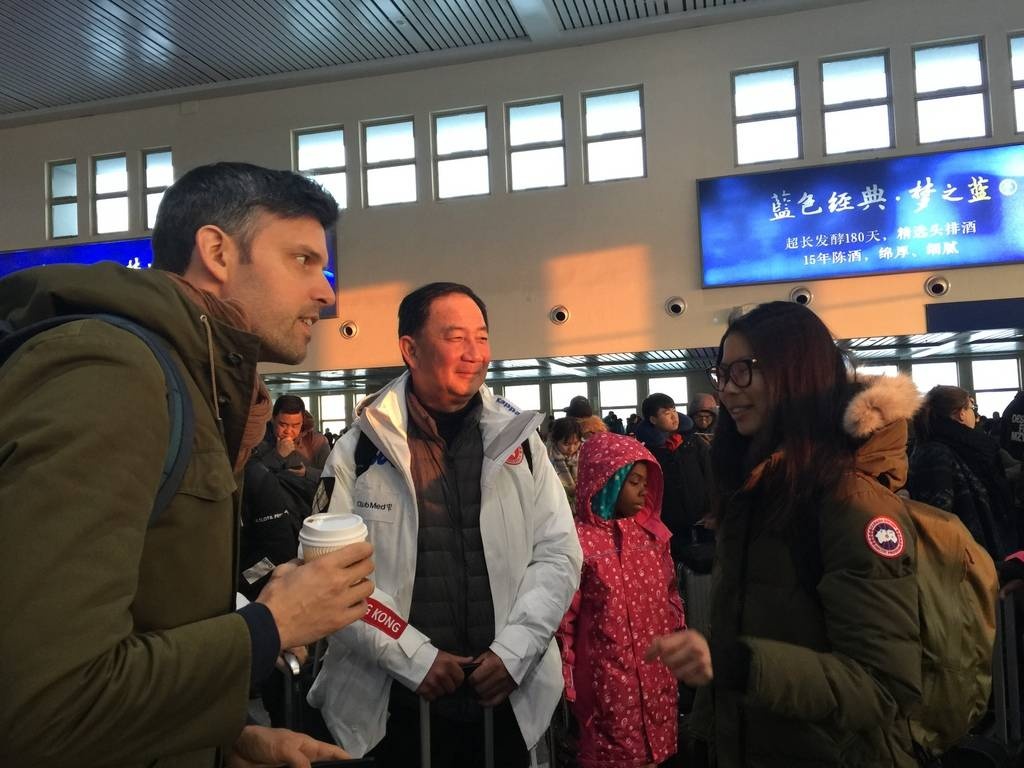 Club Med香港及澳門地區總經理Sebastien Portes與香港滑雪總會秘書長Samson Siu在哈爾濱火車站，歡迎從法國獨自飛來、參加訓練的女選手Emma Huang。