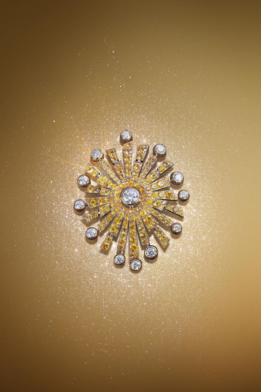 Soleil Talisman 以鮮見的黃K 金鑲嵌鑽石與黃色藍寶石的組合，向皎陽似火、光芒萬丈的壯麗景象獻上最華美的禮讚。太陽胸針的正中央鑲嵌了一顆圓形切割鑽石，絢麗的光澤能夠點亮任何一款造型。